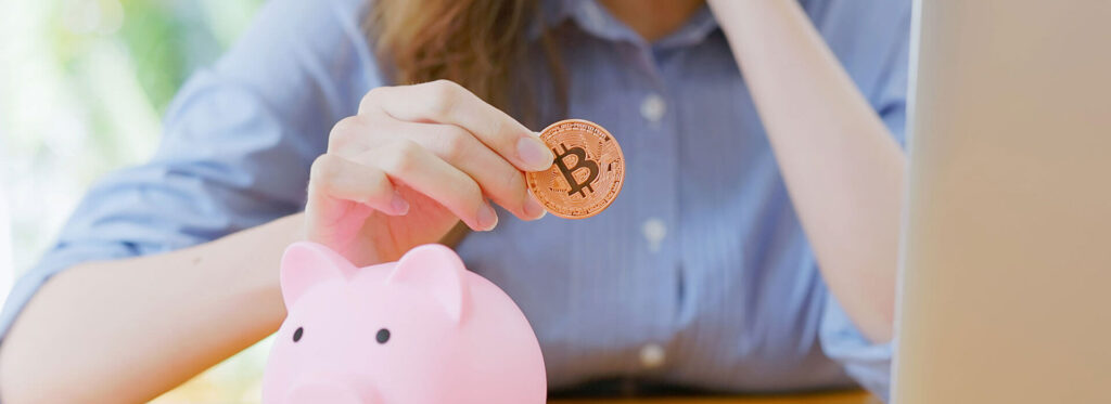 woman holding bitcoin near piggy bank