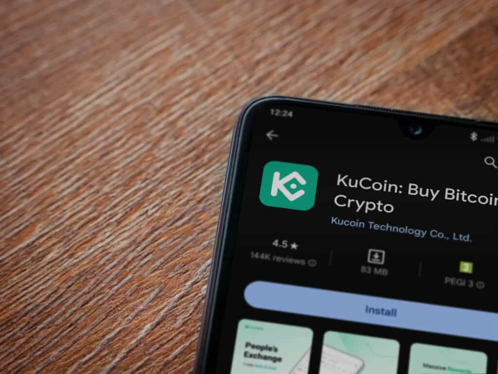 KuCoin logo mobile app on a screen smartphone closeup.