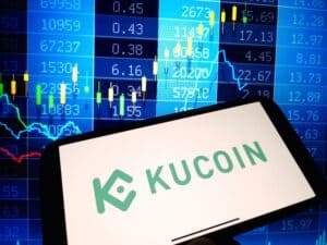 KuCoin cryptocurrency exchange logo displayed on smartphone on crypto market data background