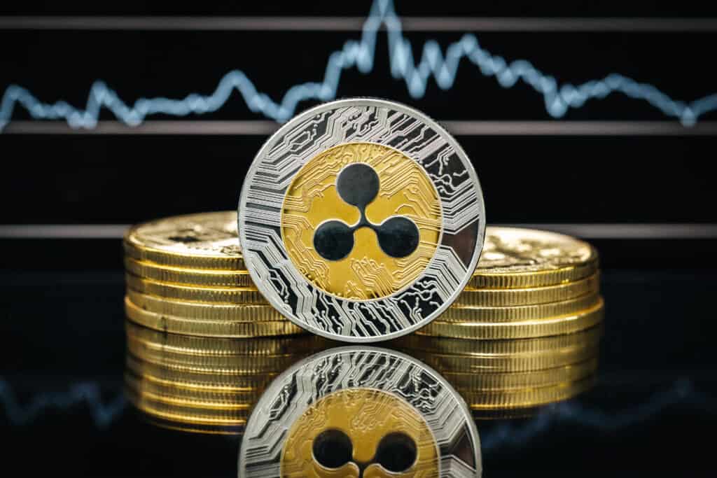 Ripple XRP cryptocurrency, physical close-up, in front of a price chart