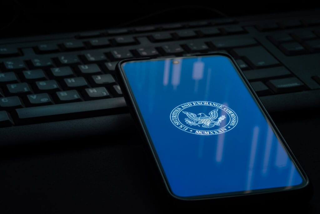 SEC logo on smartphone screen laying on computer keyboard