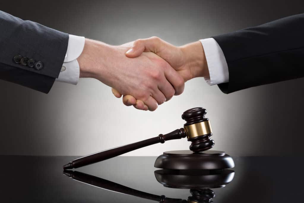 Businessman Shaking Hands In Front Of Mallet