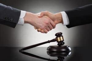 Businessman Shaking Hands In Front Of Mallet