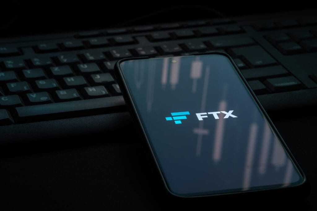 Ftx Crypto Exchange Logo on Smartphone Screen Laying on Computer Keyboard