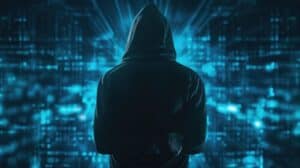 Unrecognizable hacker in black hoodie standing over dark blue background with double exposure of immersive data protection interface.