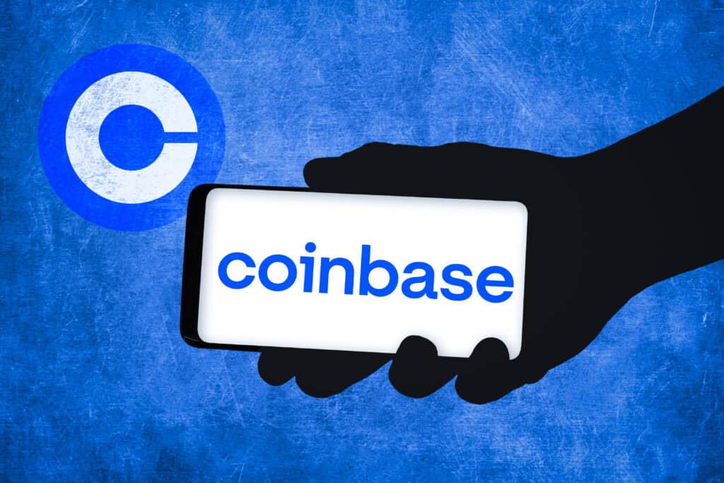 silhouette holding phone that displays Coinbase logo