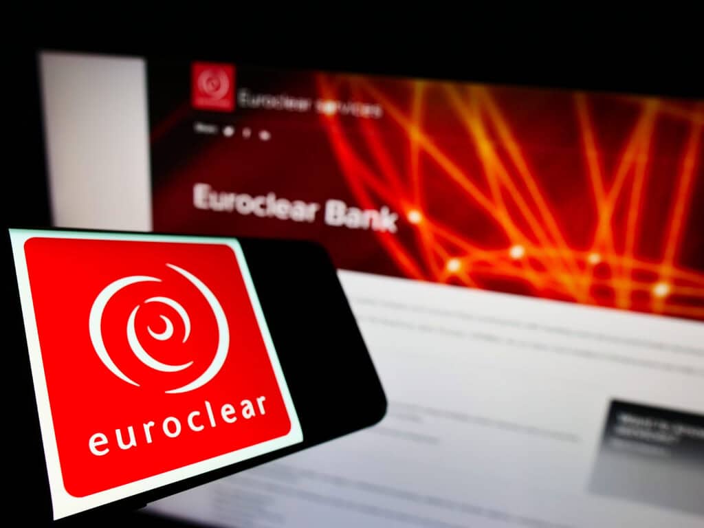 Cellphone with logo of Belgian financial company Euroclear Group on screen in front of business website.